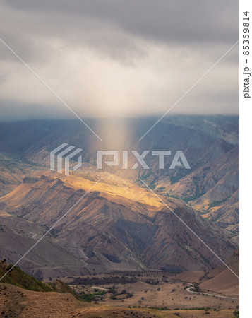 Mystical Light of heaven in the dark mountains. Dramatic sky on mountain peaks. Mystical background with dramatic mountains. Vertical view. Mystical Light of heaven in the dark mountains. Dramatic sky on mountain peaks. Mystical background with dramatic mountains. Vertical view. 85359814