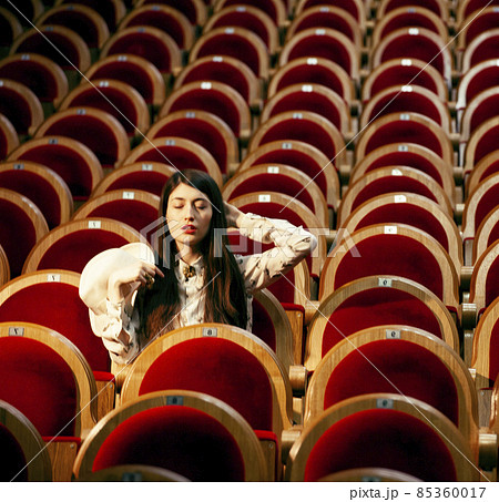 portrait of a pretty girl hipster in a movie theater wearing hat, dreaming alone, fashion lufestyle people concept 85360017