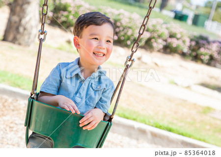 Chinese and Caucasian Boy Having Fun On The Swings At Playground. Chinese and Caucasian Boy Having Fun On The Swings At Playground. 85364018