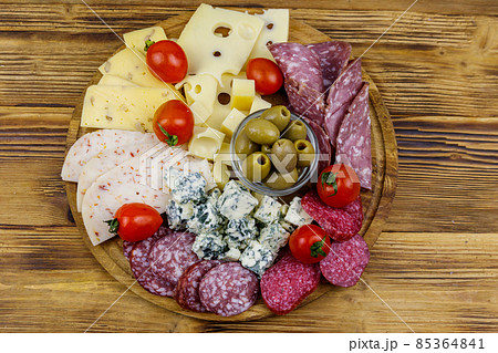 Antipasti platter with olives, cherry tomatoes, assortment of italian salami and cheese on a wooden table. Top view Antipasti platter with olives, cherry tomatoes, assortment of italian salami and cheese on a wooden table. Top view 85364841