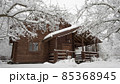 Snow covered country house made of brown logs 85368945