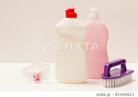 Bottles of dishwashing liquid and brush on white background. Bottles of dishwashing liquid and brush on white background. 85369021