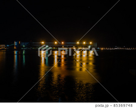Night seascape with a large metal structure on the pier illuminated by bright lights Night seascape with a large metal structure on the pier illuminated by bright lights 85369748