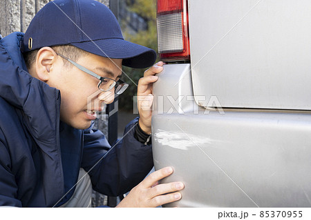 仕事中に車を傷つけて困る男性 85370955