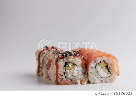 a portion of rolls on a stand, japanese food, sushi on the table, chinese chopsticks, light background 85376022