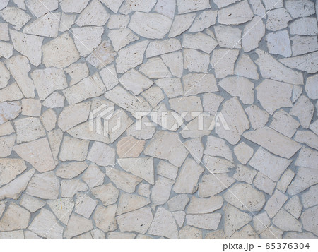 The wall is lined with light gray beige decorative tiles of various shapes. Full screen photo. Not seamless texture The wall is lined with light gray beige decorative tiles of various shapes. Full screen photo. Not seamless texture 85376304