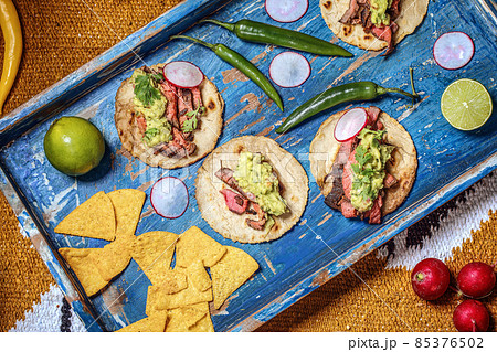 Process of cooking tacos with grilled flank beef steak with handmade guacomole 85376502