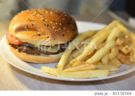 Hamburger with meat and fries on a plate 85376568