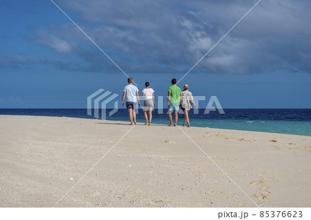 Group of White Caucasian Friends Walking on the Beach with Perfect White Sand 85376623