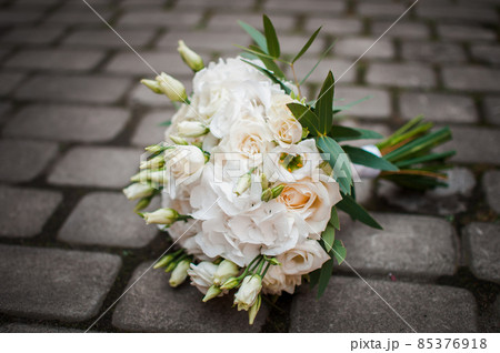 Bouquet of flowers lies on the pavement 85376918
