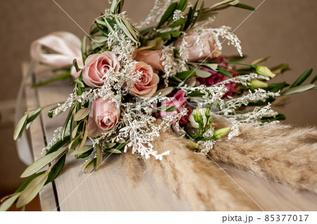 Bouquet of roses and white feather on the table Bouquet of roses and white feather on the table 85377017