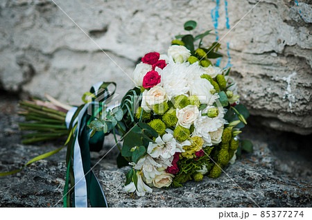 Colorfull bouquet of flowers lying on the rocks Colorfull bouquet of flowers lying on the rocks 85377274