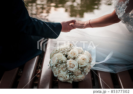 Bouquet of flowers and couple of hands on the table Bouquet of flowers and couple of hands on the table 85377302