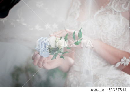 White with blue rose buttonhole in the girls hand 85377311