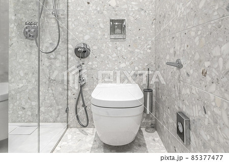 Furnished modern minimalist bathroom interior with bathroom chrome accessories and grey tiles Furnished modern minimalist bathroom interior with bathroom chrome accessories and grey tiles 85377477