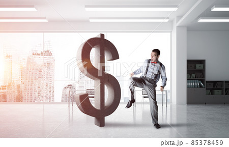 Determined banker man in modern office interior breaking dollar figure Determined banker man in modern office interior breaking dollar figure 85378459