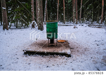 Manger for winter feeding of wild animals in forest. Forest animal feeder in winter. Defocused Manger for winter feeding of wild animals in forest. Forest animal feeder in winter. Defocused 85378828