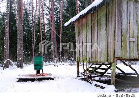 Manger for winter feeding of wild animals in forest. Forest animal feeder in winter. Defocused Manger for winter feeding of wild animals in forest. Forest animal feeder in winter. Defocused 85378829