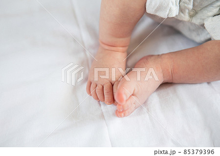 Small feet of a newborn baby on the bed, top view. The concept of motherhood, breastfeeding. 85379396