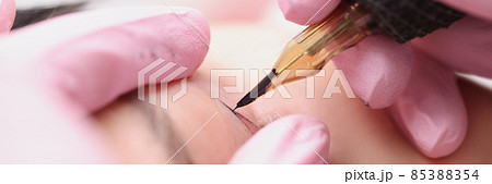 Master make-up artist makes permanent makeup for a client eyelids 85388354
