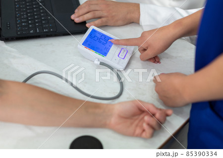 The nurse shows the total blood pressure result. The nurse shows the total blood pressure result. 85390334