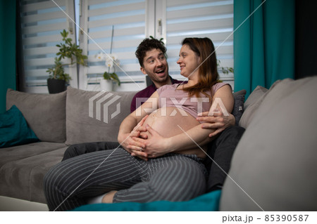 The husband exclaims with joy that he is going to have a son and the wife smiles warmly. Pregnant woman. 85390587