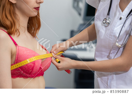A doctor measures the chest circumference of a young patient. On the second combustible ultrasound machine. A doctor measures the chest circumference of a young patient. On the second combustible ultrasound machine. 85390887