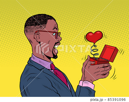 A businessman man looks at a red heart box valentine surprise greeting, love romance 85391096