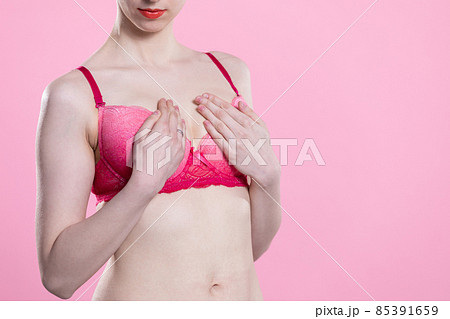 The woman performs a breast self-examination and checks for hard spots or lumps. The woman performs a breast self-examination and checks for hard spots or lumps. 85391659