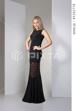 young beautiful brunette in black dress on white 85392778