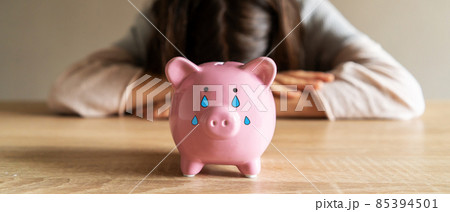 Sad girl with a crying piggy bank. Sad girl with a crying piggy bank. 85394501