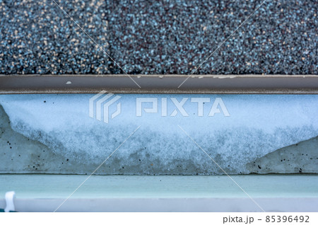 Ice and snow building up inside a rooftop gutter system on a residential house Ice and snow building up inside a rooftop gutter system on a residential house 85396492