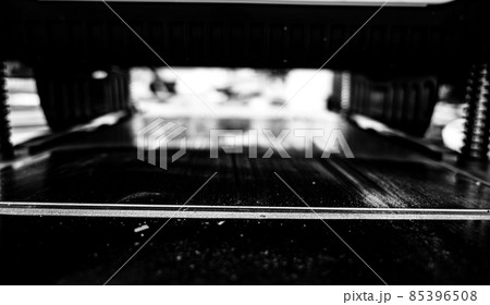 Selective focus looking into a wood planer bed raised above the board 85396508