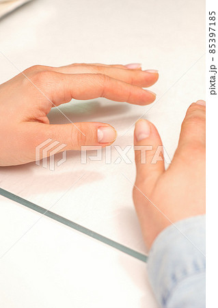 Hands of a young woman with well-groomed nails on the manicure table. 85397185