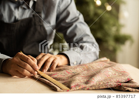 布を裁つ職人の手元 85397717