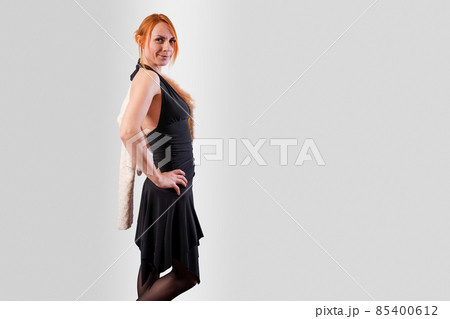 Girl in a black evening dress, on a gray background Girl in a black evening dress, on a gray background 85400612