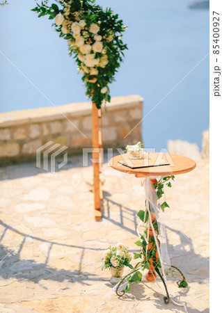 Small table stands in front of the wedding arch on an observation deck overlooking the sea 85400927