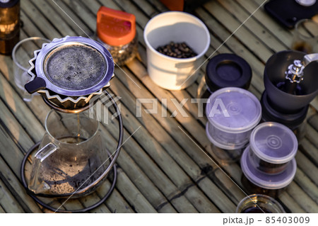 Kit for drip coffee with cup on a bamboo table with coffee beans. Kit for drip coffee with cup on a bamboo table with coffee beans. 85403009