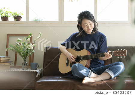 ギターを弾く若い女性 85403537