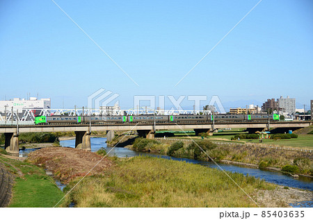 河原のくすみ始めた緑と対照的に車両の鮮やかな緑が目立つ特急「ライラック」 85403635