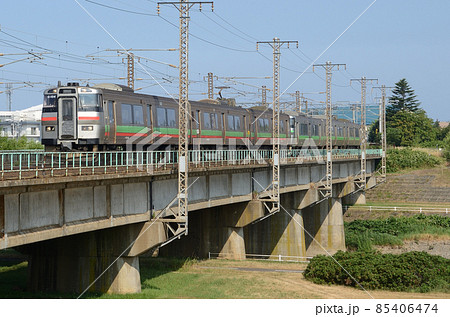 豊平川橋梁を渡り函館本線を岩見沢へ歩みを進めていく普通列車 85406474
