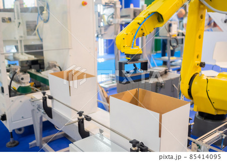 Yellow robotic arm manipulator working with cardboard boxes - sorting system Yellow robotic arm manipulator working with cardboard boxes - sorting system 85414095