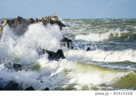 an autumn storm rages in the baltic sea, hitting the waves against a breakwater 85414208