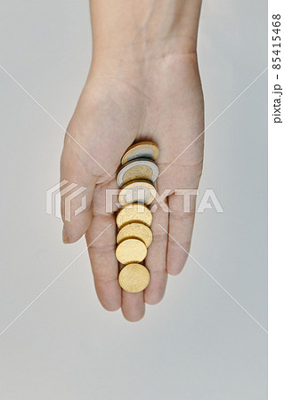 Flat lay of coins in women's hand. Concept of alms and donations. Small savings. Expenses and earnings. 85415468