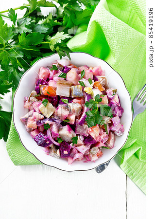 Salad with herring and beetroot in bowl on light board top Salad with herring and beetroot in bowl on light board top 85419196