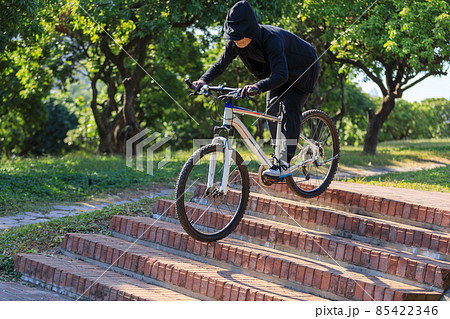 Woman free rider riding bike going down city stairs Woman free rider riding bike going down city stairs 85422346