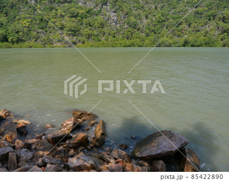 Rocky reef and stone in the green water of sea with mountain and island in background, Thailand Rocky reef and stone in the green water of sea with mountain and island in background, Thailand 85422890