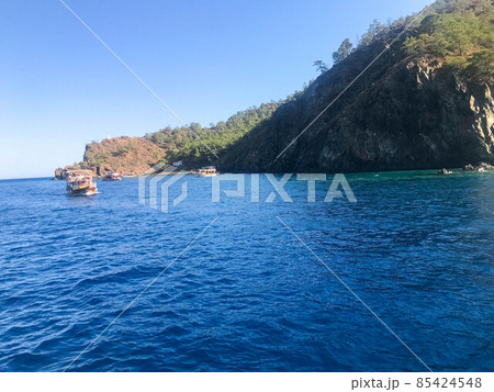 Beautiful blue sea and small ships against the backdrop of high mountains in a warm tourist tropical country. Landscape 85424548