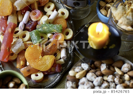 Black Turkish tea in lale with oriental sweets and dried fruits by candlelight Black Turkish tea in lale with oriental sweets and dried fruits by candlelight 85426765
