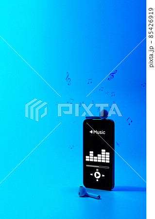 Music background. Mobile smartphone screen with music application, sound headphones. Audio voice with radio beats on blue gradient. Recording studio or podcasting banner with copy space. Music background. Mobile smartphone screen with music application, sound headphones. Audio voice with radio beats on blue gradient. Recording studio or podcasting banner with copy space. 85426919